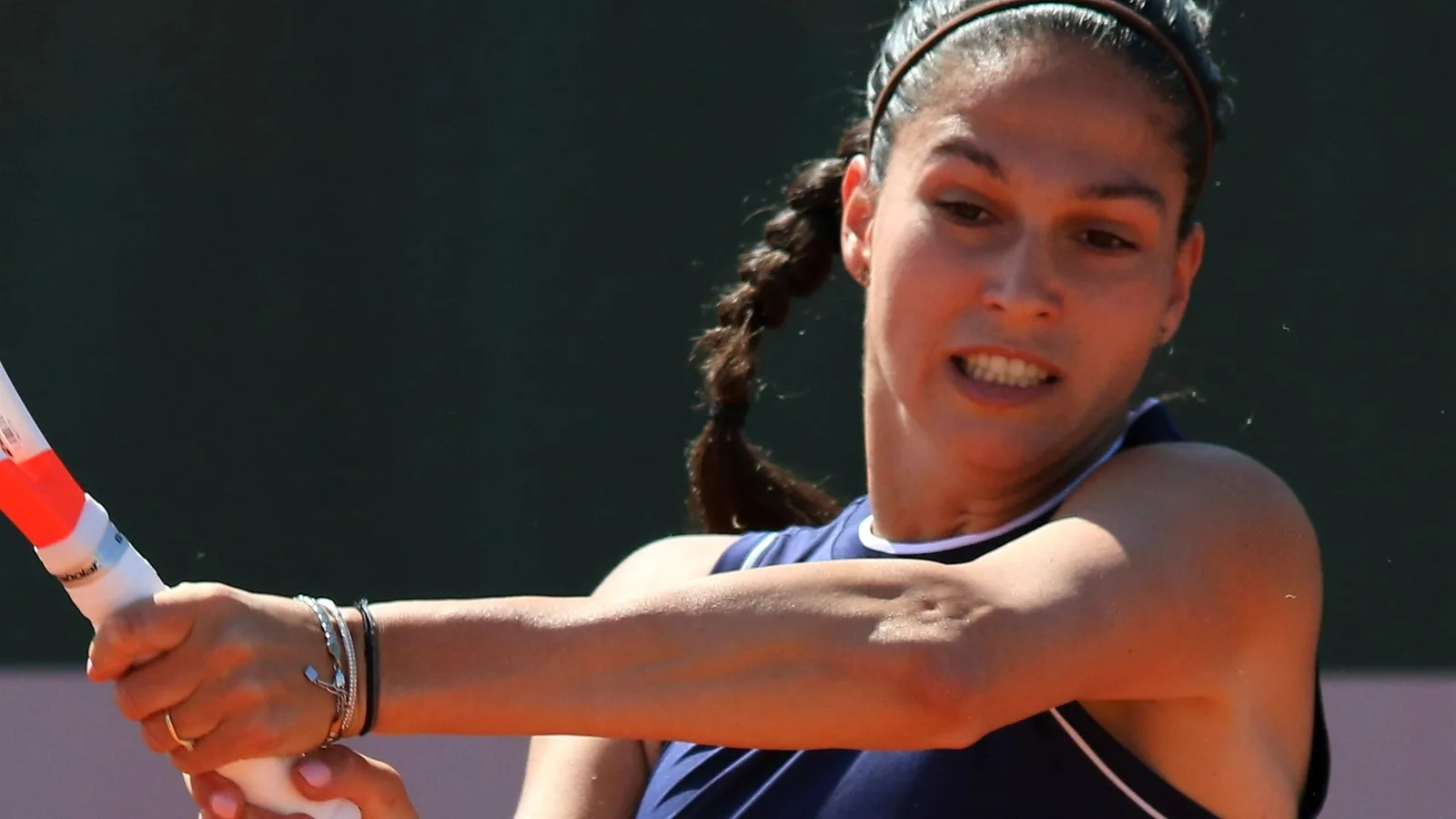 Изабелла Шиникова изпълнява бекхенд на клей по време на квалификациите на Ролан Гарос през 2022 година