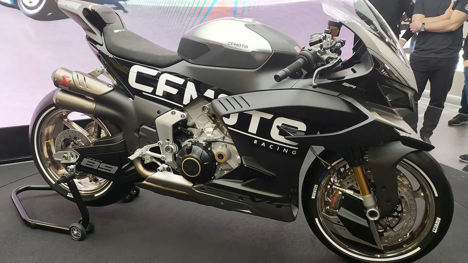 CFMoto SR-RR V4 Prototype на изложение през 2025 г. — архивен кадър, не от състезание през 2027 г. MotorideSA / Wikimedia Commons, CC BY-SA 4.0; оригинал: https://commons.wikimedia.org/wiki/File:CFMoto_SR-RR_V4_Prototype.jpg ; лиценз: https://creativecommons.org/licenses/by-sa/4.0/ ; изрязано до 16:9, производното изображение е под CC BY-SA 4.0.