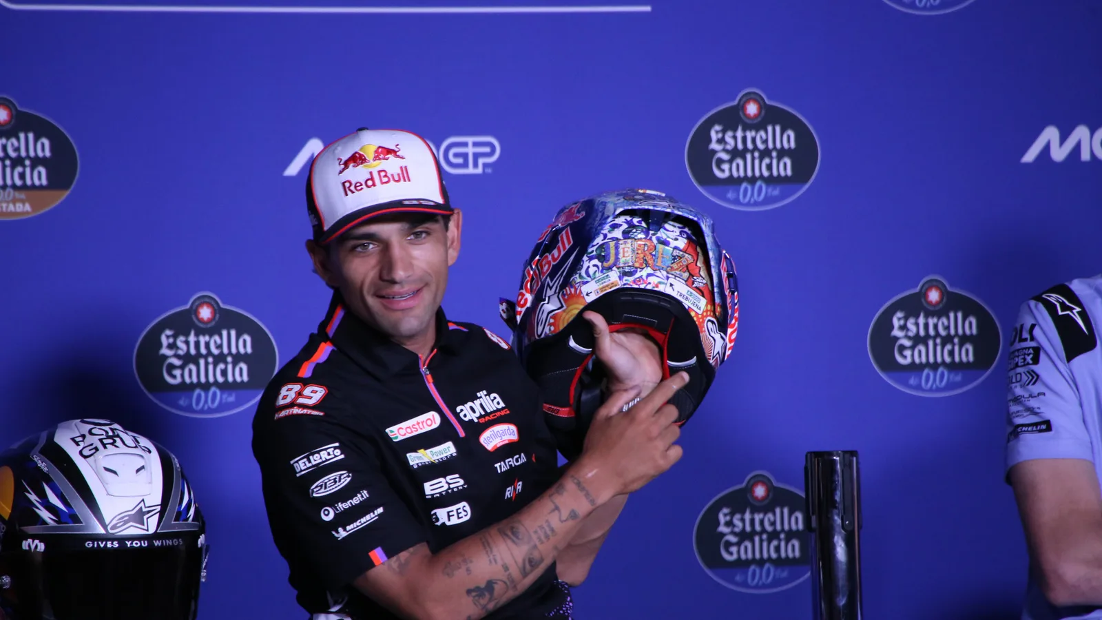 Архив: Хорхе Мартин с Aprilia показва специалната си каска в Херес, 23 април 2026 г.; не е кадър от контузията или Малайзия. René 2782 / Wikimedia Commons, CC BY-SA 4.0; https://creativecommons.org/licenses/by-sa/4.0/ . Изрязано и оразмерено до 16:9 без AI редакция; производното остава под същия лиценз. Оригинал: https://commons.wikimedia.org/wiki/File:Jorge_Mart%C3%ADn_Jerez_GP_2026_casco_speciale_2.jpg