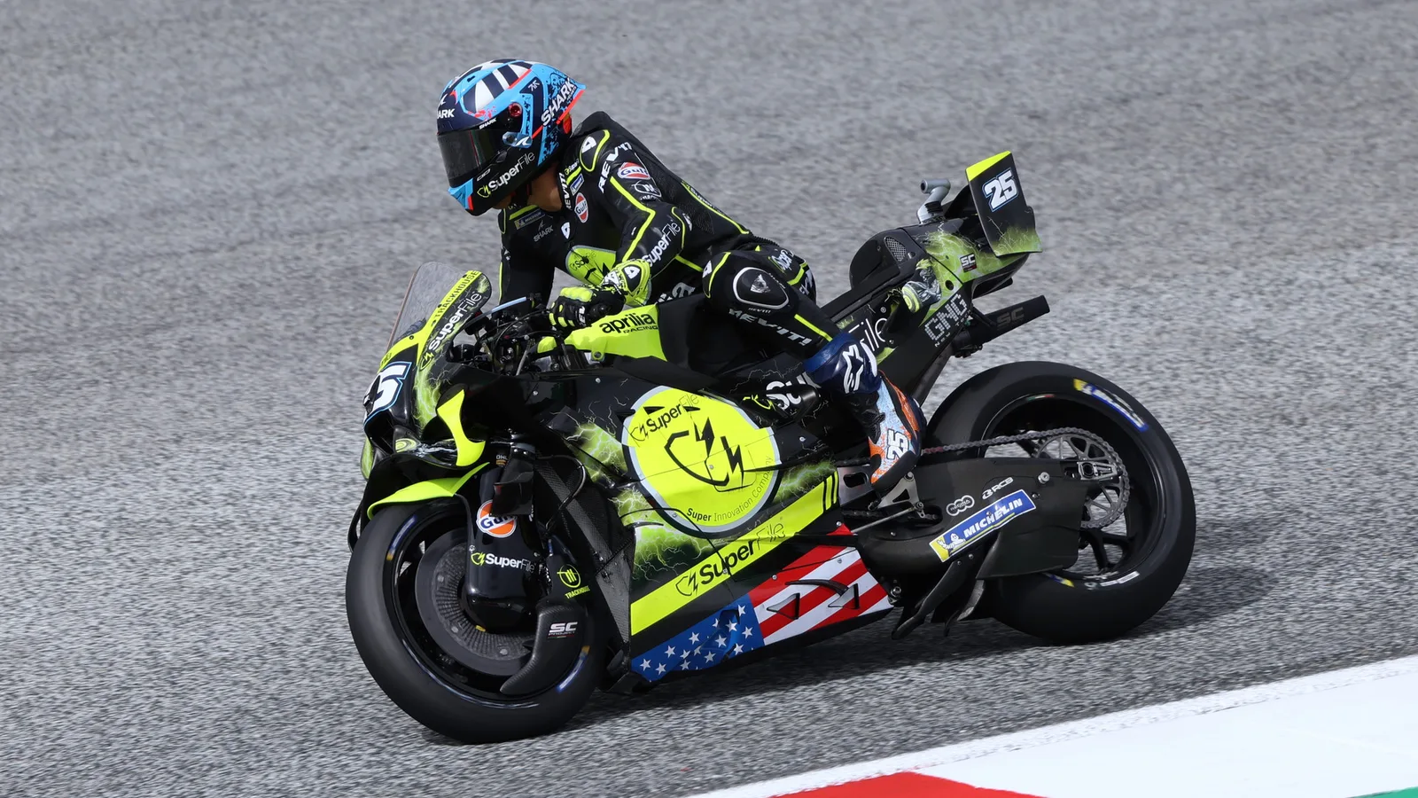 Архив: Раул Фернандес с Trackhouse Aprilia №25 в Австрия, 18 септември 2026 г.; не е кадър от Малайзия. Lukas Raich / Wikimedia Commons, CC BY-SA 4.0, https://creativecommons.org/licenses/by-sa/4.0/ . Минимално изрязано и оразмерено до 1920×1080 без AI редакция; производното остава под същия лиценз. Оригинал: https://commons.wikimedia.org/wiki/File:MotoGP_2026_Austria_Nr._25_Fern%C3%A1ndez_(1).jpg