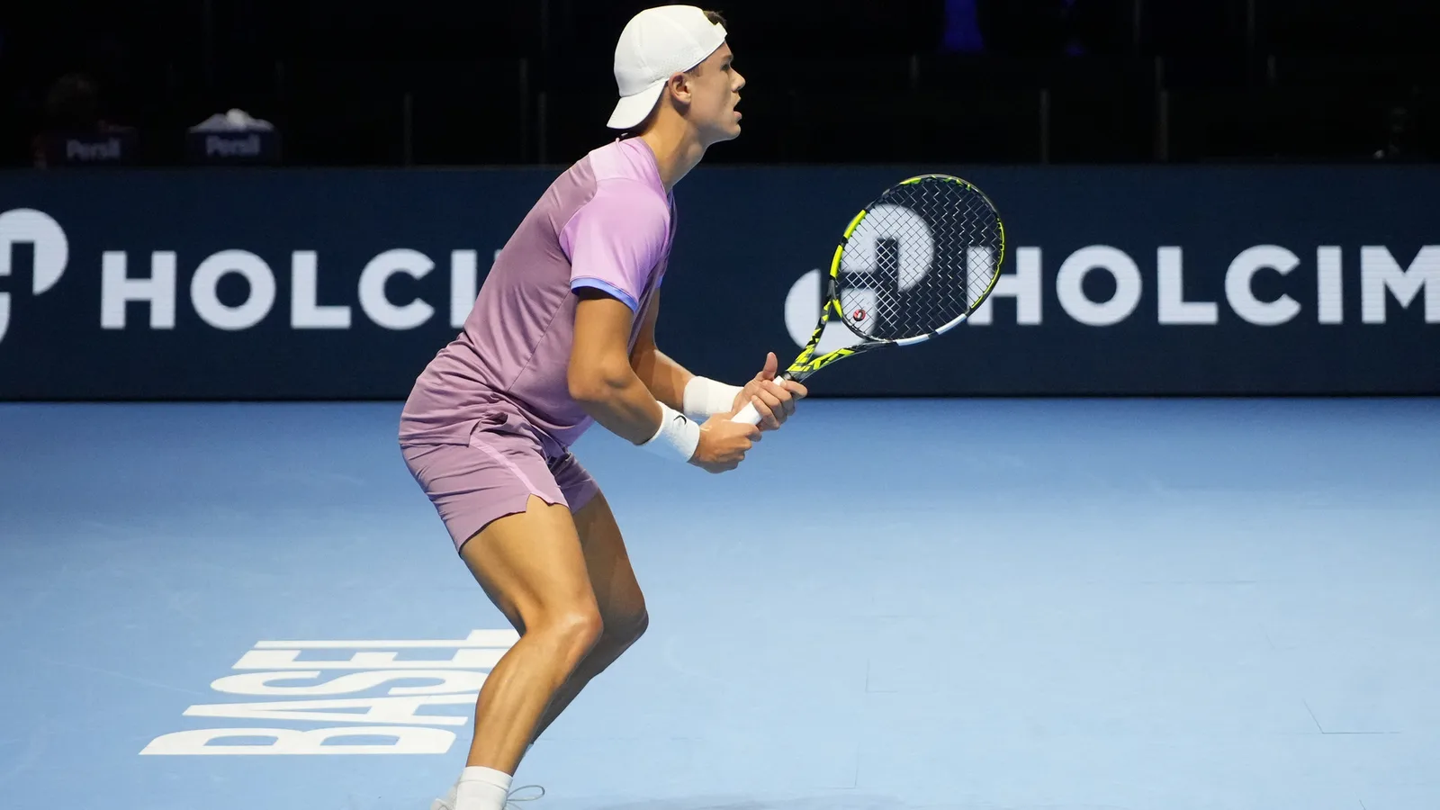 Архив: Холгер Руне на Swiss Indoors в Базел, 25 октомври 2024 г.; не е кадър от победата над Алис през 2026 г. Swiss Indoors / Wikimedia Commons, CC BY-SA 4.0. https://commons.wikimedia.org/wiki/File:Holger_Rune,_Swiss_Indoors_Basel_2024.jpg ; https://creativecommons.org/licenses/by-sa/4.0/ ; изрязано и преоразмерено до 16:9 без AI редакция, адаптация под същия лиценз.