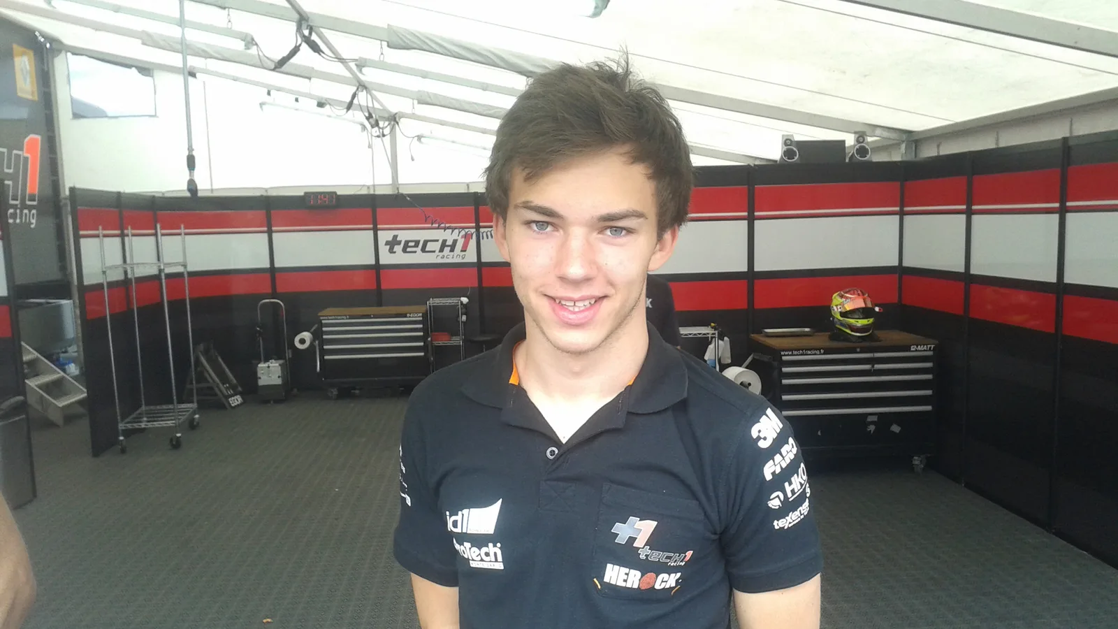 Архивен портрет на Пиер Гасли в състезателен бокс на Moscow Raceway през 2013 г.; не е кадър от спринта в Сингапур през 2026 г. Cybervoron / Wikimedia Commons, CC BY-SA 3.0; изрязано до 16:9. Оригинал: https://commons.wikimedia.org/wiki/File:Pierre_Gasly.jpg ; лиценз: https://creativecommons.org/licenses/by-sa/3.0/ ; производното изображение остава под CC BY-SA 3.0.
