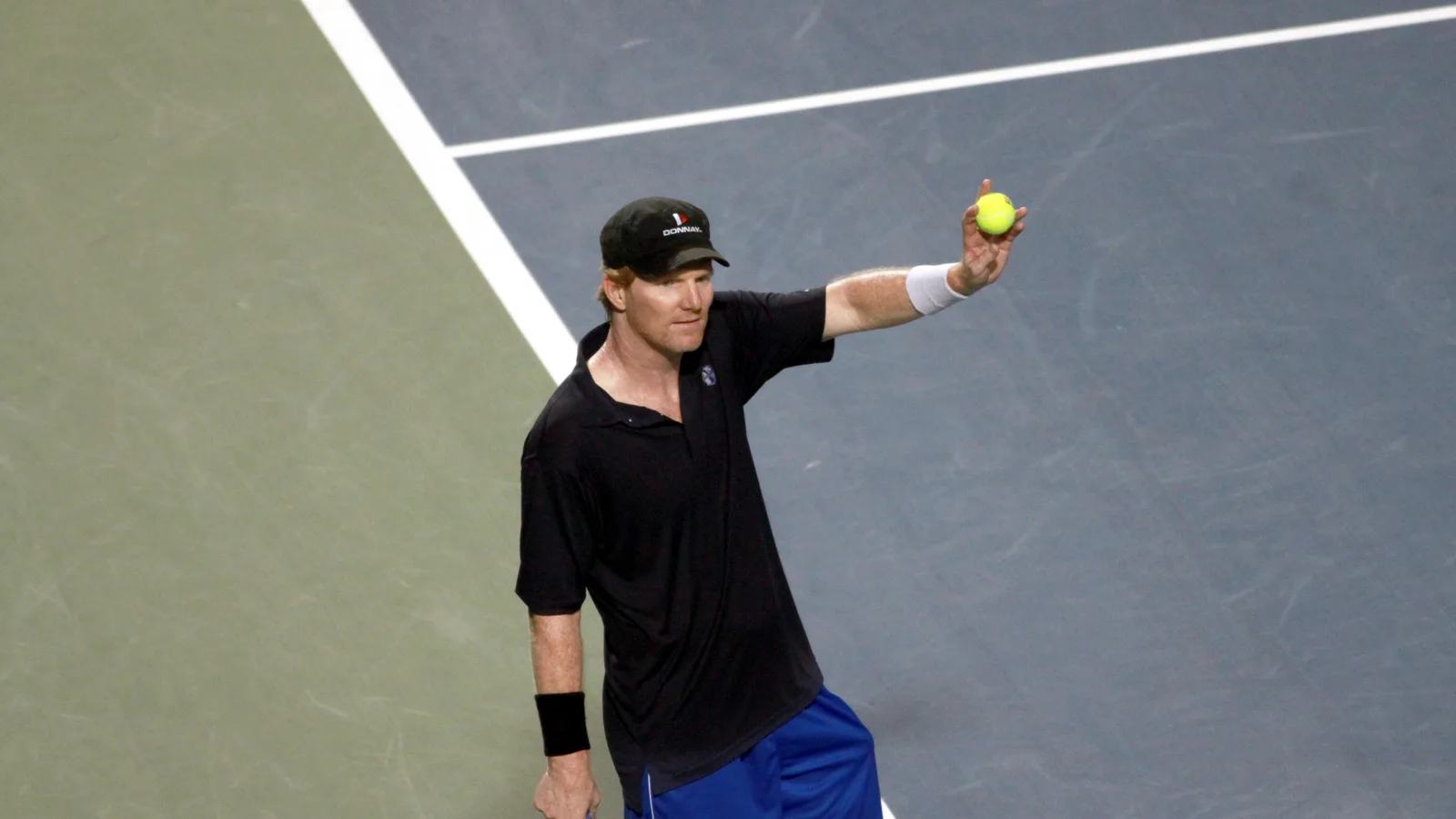 Джим Къриър на корта по време на демонстративен мач на Rogers Cup през 2011 г. — архивна снимка, не от финала в Базел през 1989 г. ZankaM / Wikimedia Commons, CC BY-SA 3.0; оригинал: https://commons.wikimedia.org/wiki/File:RogersCup2011_Legends_JimCourier1_mod.jpg ; лиценз: https://creativecommons.org/licenses/by-sa/3.0/ ; изрязана до 16:9, адаптацията е под CC BY-SA 3.0.