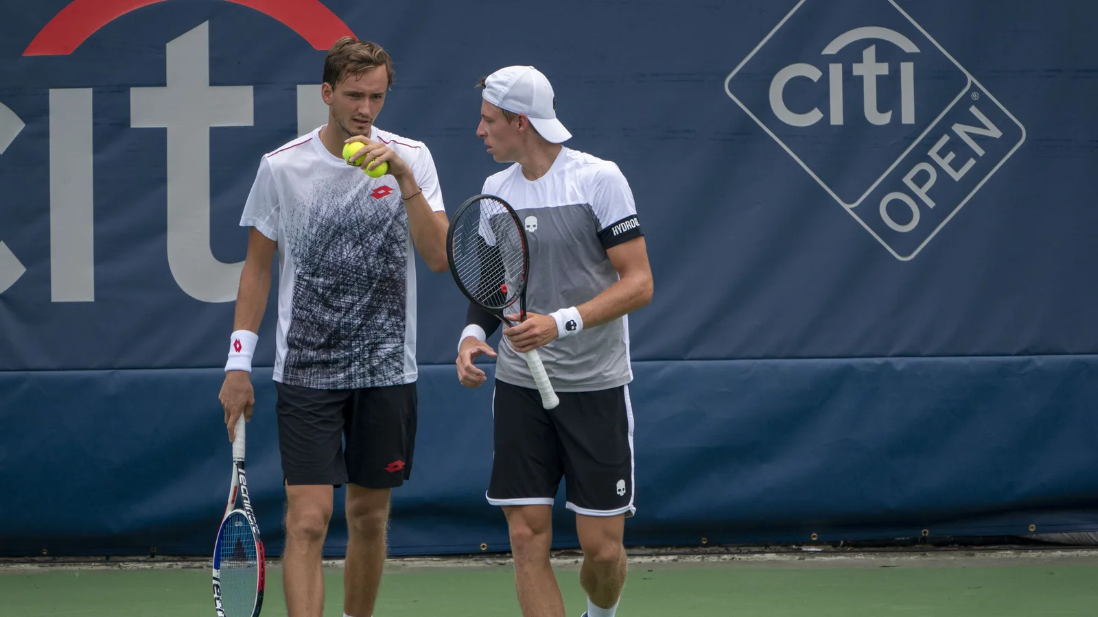 Архив: Даниил Медведев (вляво) с Иля Ивашка на Citi Open през юли 2018 г.; не е кадър от срещата с Циципас в Шанхай. Keith Allison / Wikimedia Commons, CC BY-SA 2.0; оригинал: https://commons.wikimedia.org/wiki/File:Daniil_Medvedev,_Ilya_Ivashka_(29854010788).jpg ; лиценз: https://creativecommons.org/licenses/by-sa/2.0/ ; изрязано до 16:9, адаптация под същия лиценз.