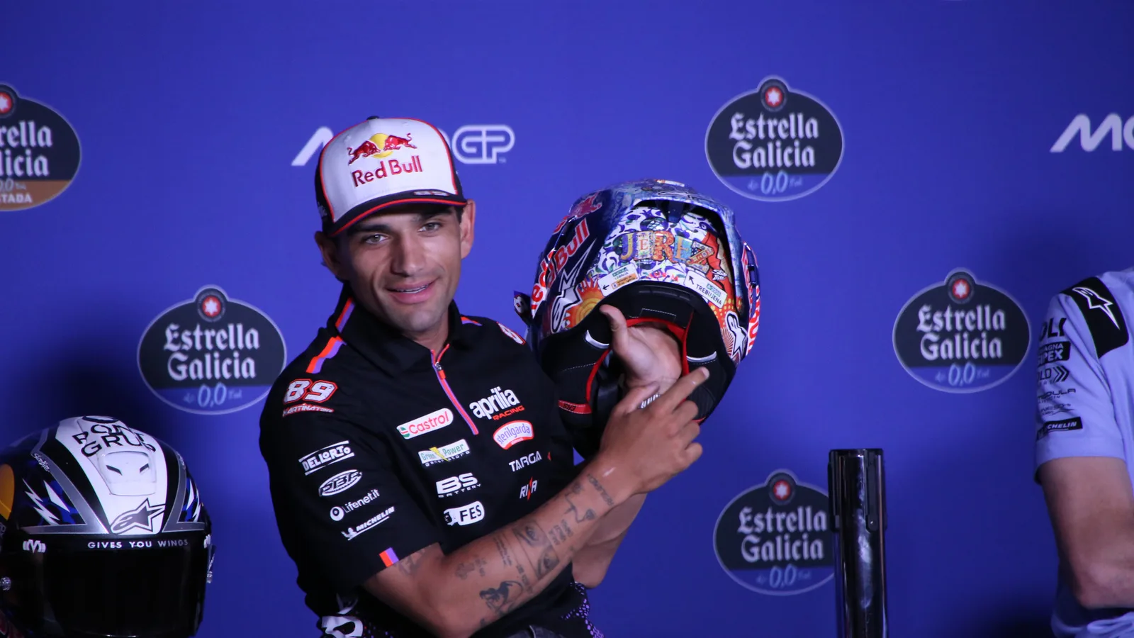 Архив: Хорхе Мартин с Aprilia показва специалния си шлем на Гран при на Испания в Херес, април 2026 г.; не е кадър от Филип Айлънд. René 2782 / Wikimedia Commons, CC BY-SA 4.0. Оригинал: https://commons.wikimedia.org/wiki/File:Jorge_Mart%C3%ADn_Jerez_GP_2026_casco_speciale_2.jpg ; лиценз: https://creativecommons.org/licenses/by-sa/4.0/ ; изрязано и оразмерено до 16:9; производното остава под CC BY-SA 4.0.