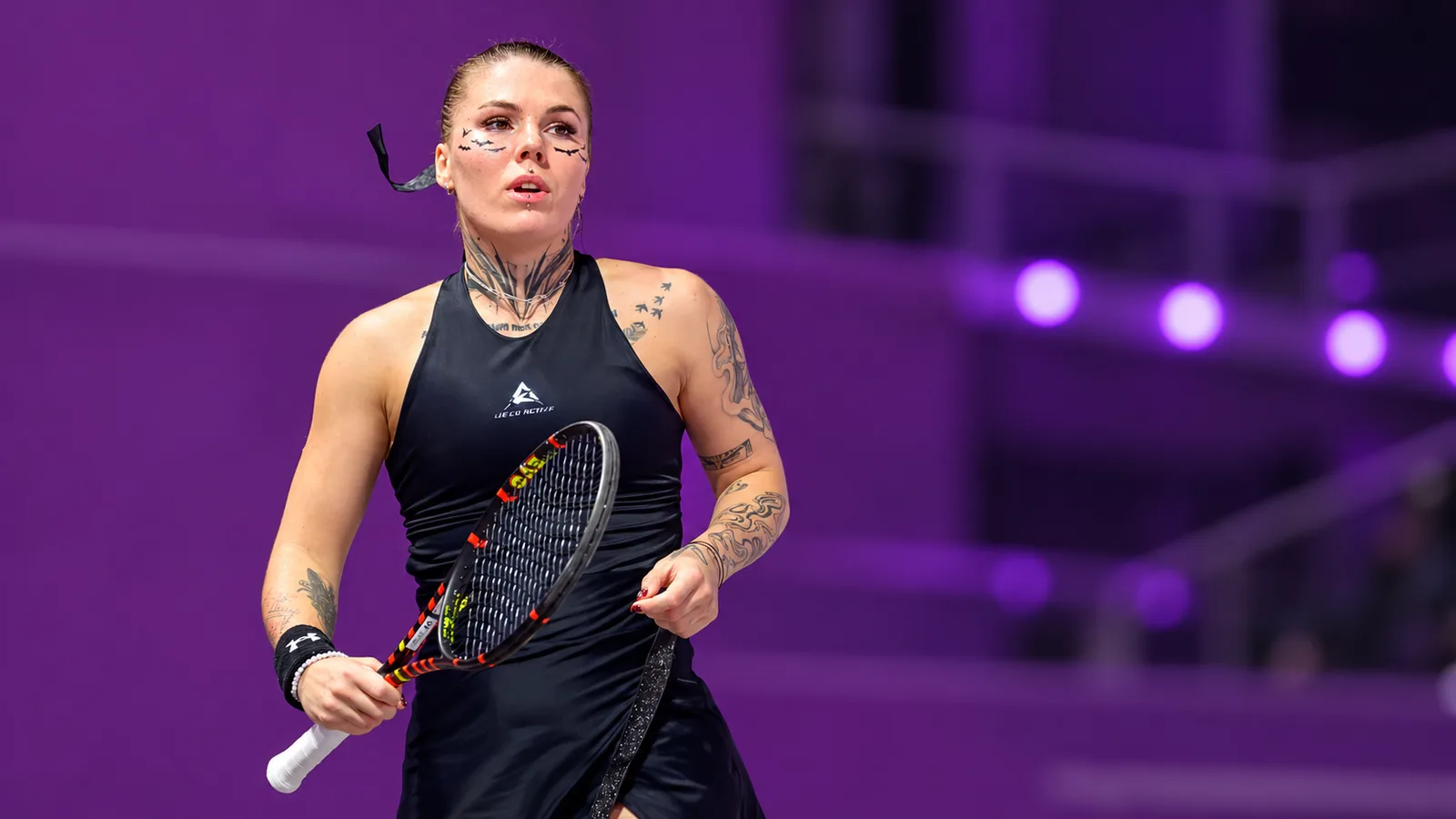 Олександра Олийникова на турнира Transylvania Open през февруари 2026 г. — архивен кадър, редакционно разширен с AI до 16:9; не е от мача с Альона Фалей в Суджоу. Nuță Lucian / Wikimedia Commons, производна редакция Kacir, CC BY-SA 4.0: https://commons.wikimedia.org/wiki/File:Oleksandra_Oliynykova_Transylvania_Open_2026_(cropped).jpg ; https://creativecommons.org/licenses/by-sa/4.0/ . Тази редакция се предоставя при CC BY-SA 4.0.