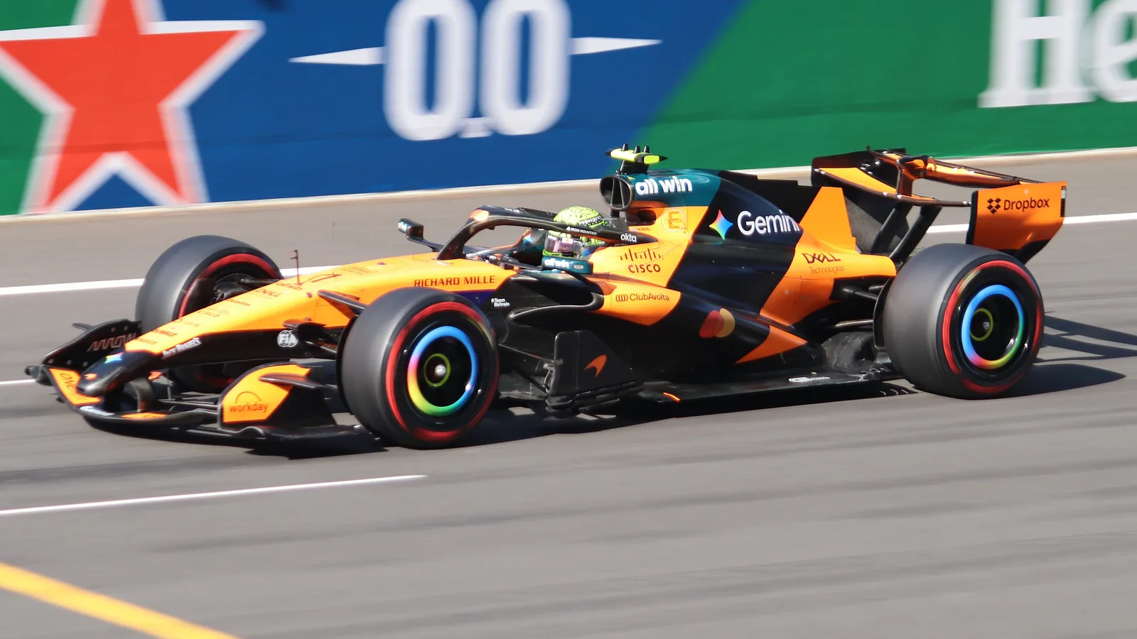 Архив: Ландо Норис с McLaren MCL40 в квалификацията за Гран при на Китай, 14 март 2026 г.; не е кадър от Остин. Liauzh / Wikimedia Commons, CC BY 4.0. Оригинал: https://commons.wikimedia.org/wiki/File:2026_Chinese_GP_-_McLaren_-_Lando_Norris_-_Qualifying.jpg ; лиценз: https://creativecommons.org/licenses/by/4.0/ ; минимално изрязано и оразмерено до 1920×1080, без AI редакция.