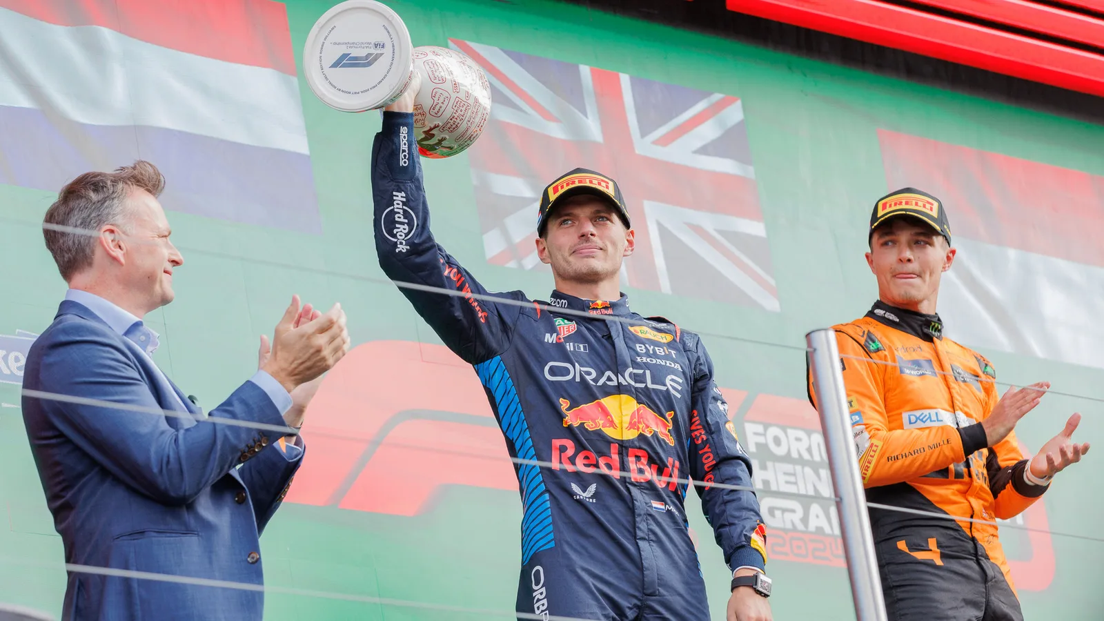 Архив: Макс Верстапен с Red Bull на подиума в Зандвоорт, 25 август 2024 г.; не е кадър от Остин 2026. Steffen Prößdorf / Wikimedia Commons, CC BY-SA 4.0; https://creativecommons.org/licenses/by-sa/4.0/ . Изрязано и оразмерено до 16:9 без AI редакция; производното е под същия лиценз. Оригинал: https://commons.wikimedia.org/wiki/File:2024-08-25_Motorsport,_Formel_1,_Gro%C3%9Fer_Preis_der_Niederlande_2024_STP_3989_by_Stepro.jpg