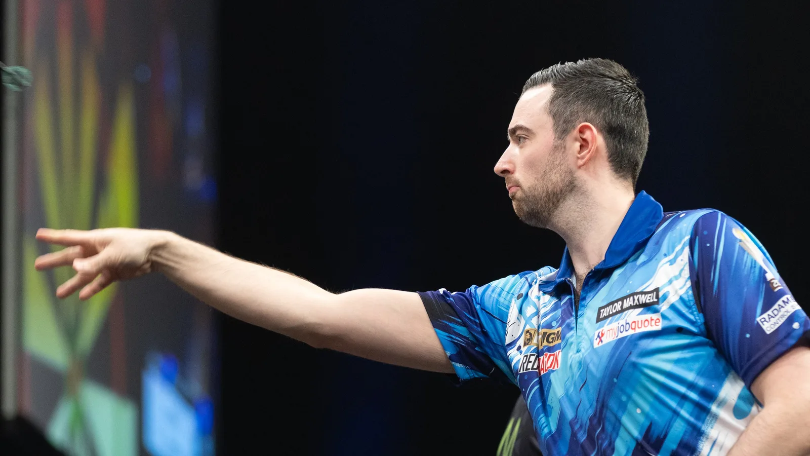 Люк Хъмфрис хвърля стрела на Premier League Darts в Берлин през март 2026 г. — архивен кадър, не от Световното Гран при в Лестър. Sandro Halank / Wikimedia Commons, CC BY-SA 4.0; оригинал: https://commons.wikimedia.org/wiki/File:2026-03-26_Premier_League_Darts_%E2%80%93_Night_8_%E2%80%93_Berlin_2026_by_Sandro_Halank%E2%80%93054.jpg ; изрязано до 16:9. Лиценз: https://creativecommons.org/licenses/by-sa/4.0/ ; редакционната преработка се разпространява при CC BY-SA 4.0.