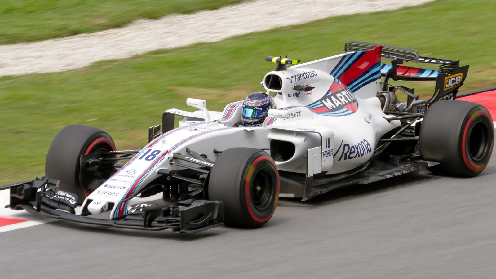 Ланс Строл с болида на Williams и гумите му на „Сепанг“ в тренировка през 2017 г. — архивен кадър, не от 2026 г. Morio / Wikimedia Commons, CC BY-SA 4.0; изрязано до 16:9. Оригинал: https://commons.wikimedia.org/wiki/File:Lance_Stroll_2017_Malaysia_FP2.jpg ; лиценз: https://creativecommons.org/licenses/by-sa/4.0/