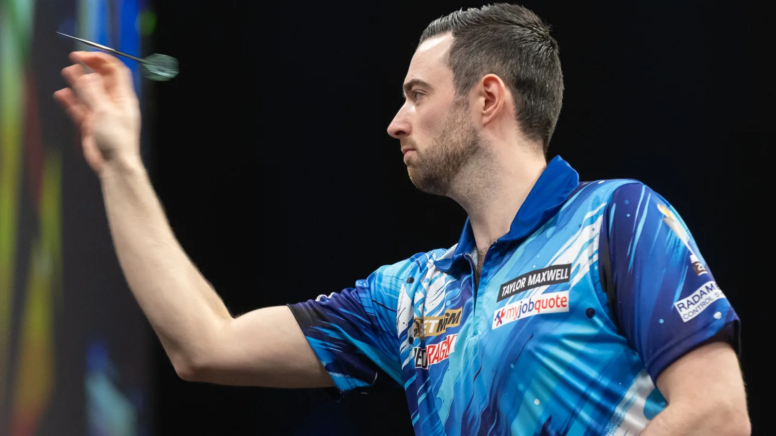 Люк Хъмфрис хвърля стрела на Premier League Darts в Берлин през март 2026 г. — архивна снимка, не от финала в Лестър. Sandro Halank / Wikimedia Commons, CC BY-SA 4.0; оригинал: https://commons.wikimedia.org/wiki/File:2026-03-26_Premier_League_Darts_%E2%80%93_Night_8_%E2%80%93_Berlin_2026_by_Sandro_Halank%E2%80%93044.jpg ; изрязана до 16:9. Лиценз: https://creativecommons.org/licenses/by-sa/4.0/ ; производната е под CC BY-SA 4.0.
