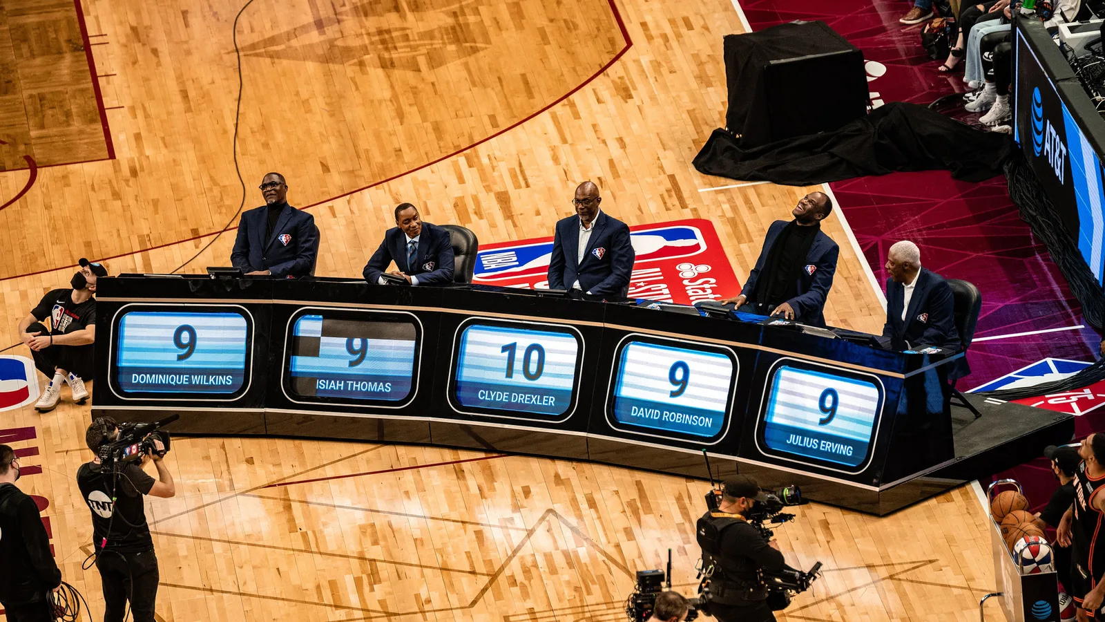 Айзея Томас (втори отляво) на церемония по време на NBA All-Star уикенда през февруари 2022 г. — архивен кадър, не от корпоративното назначение. Erik Drost / Wikimedia Commons, CC BY 2.0; изрязано до 16:9. https://commons.wikimedia.org/wiki/File:Dominique_Wilkins,_Isiah_Thomas,_Clyde_Drexler,_David_Robinson,_and_Julius_Erving_(51915620779).jpg ; https://creativecommons.org/licenses/by/2.0/